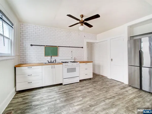 a kitchen with a refrigerator window and white cabinets