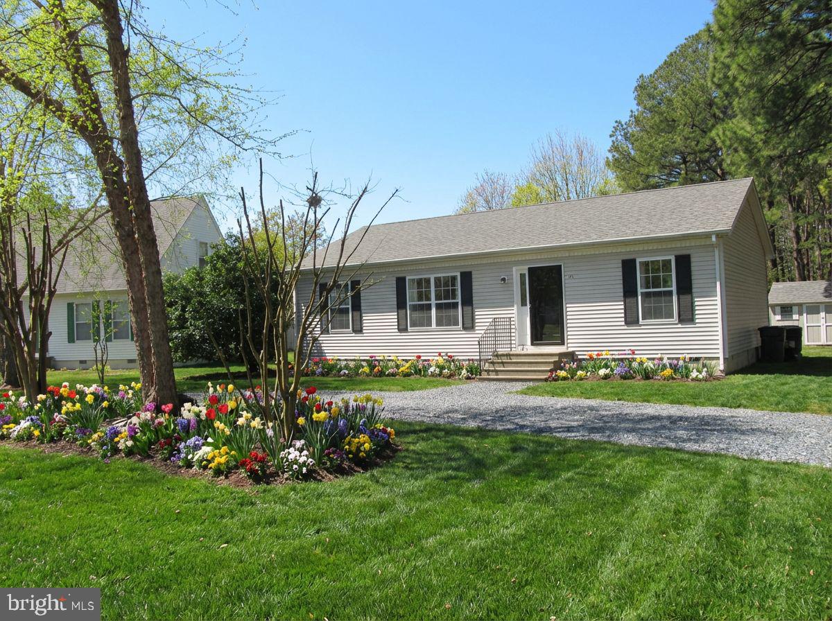 a front view of a house with a garden and plants