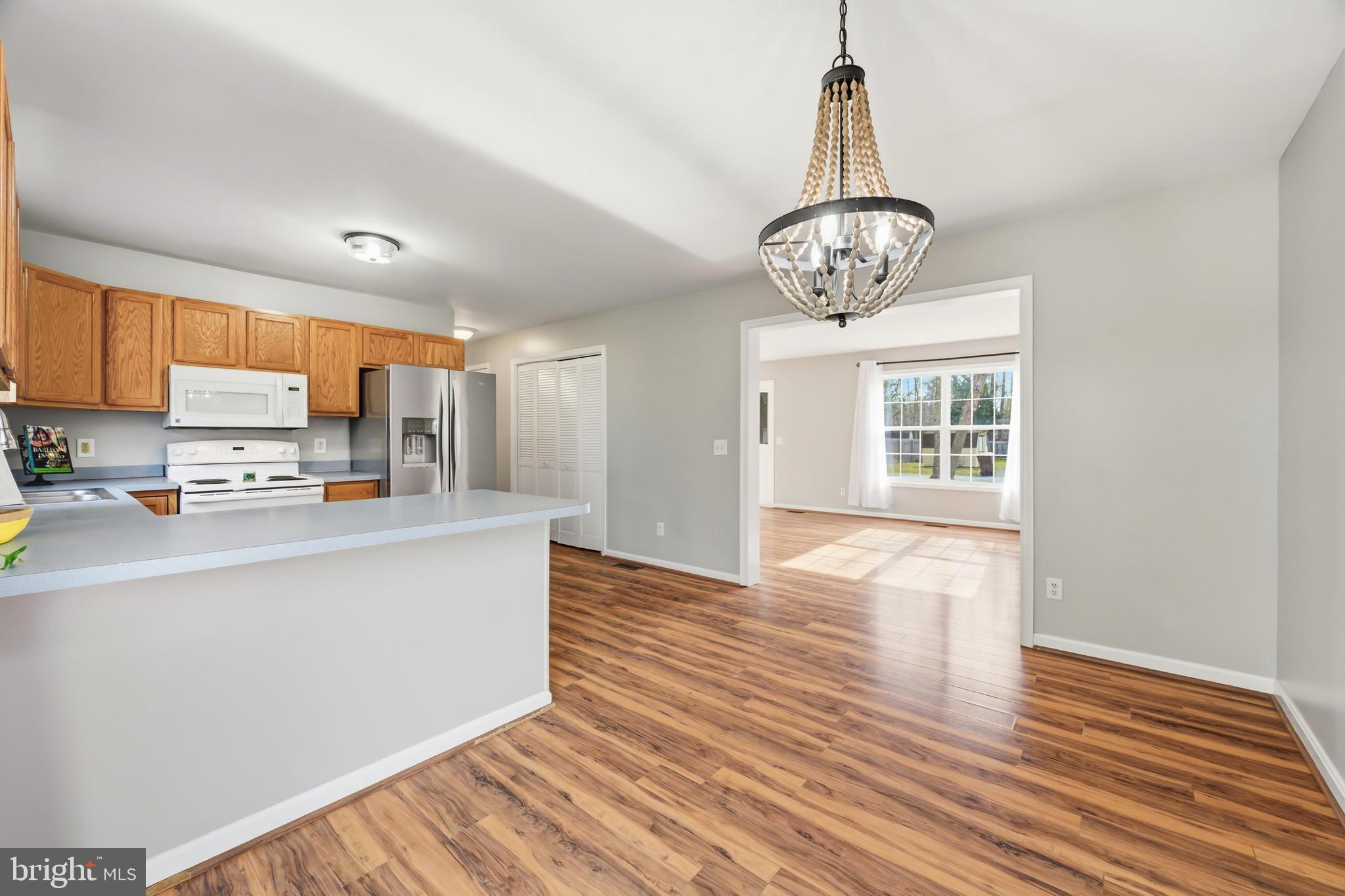 100 Bush Terrace St. Michaels, MD 21663 - Photo 11 of 40 a view of a kitchen with stainless steel appliances wooden floor and a chandelier