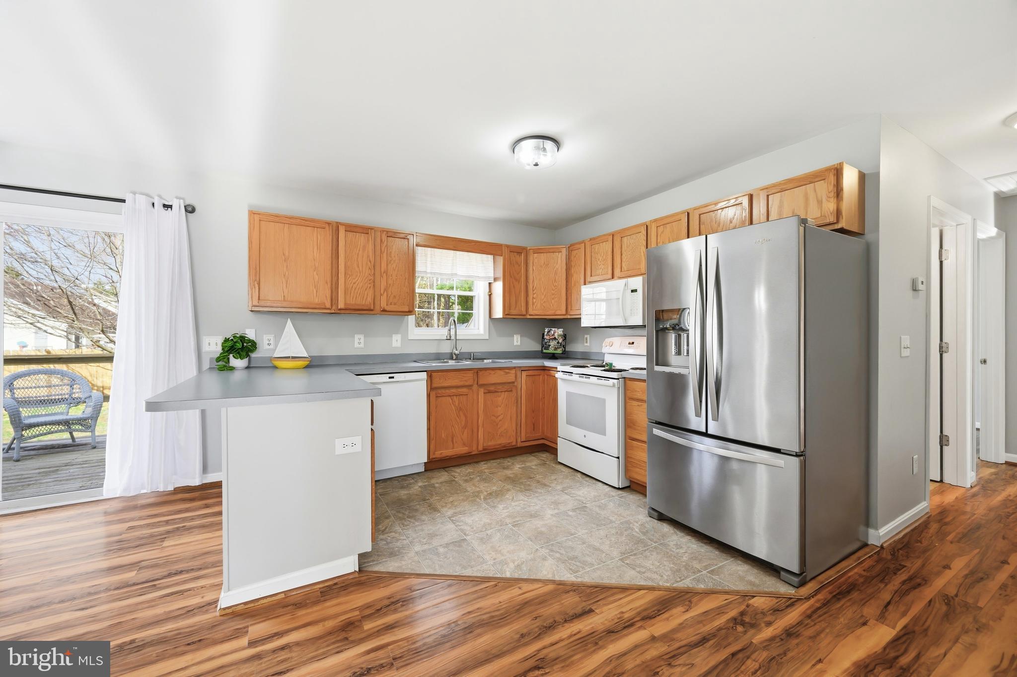 100 Bush Terrace St. Michaels, MD 21663 - Photo 12 of 40 a kitchen with granite countertop stainless steel appliances a refrigerator cabinets and wooden floor