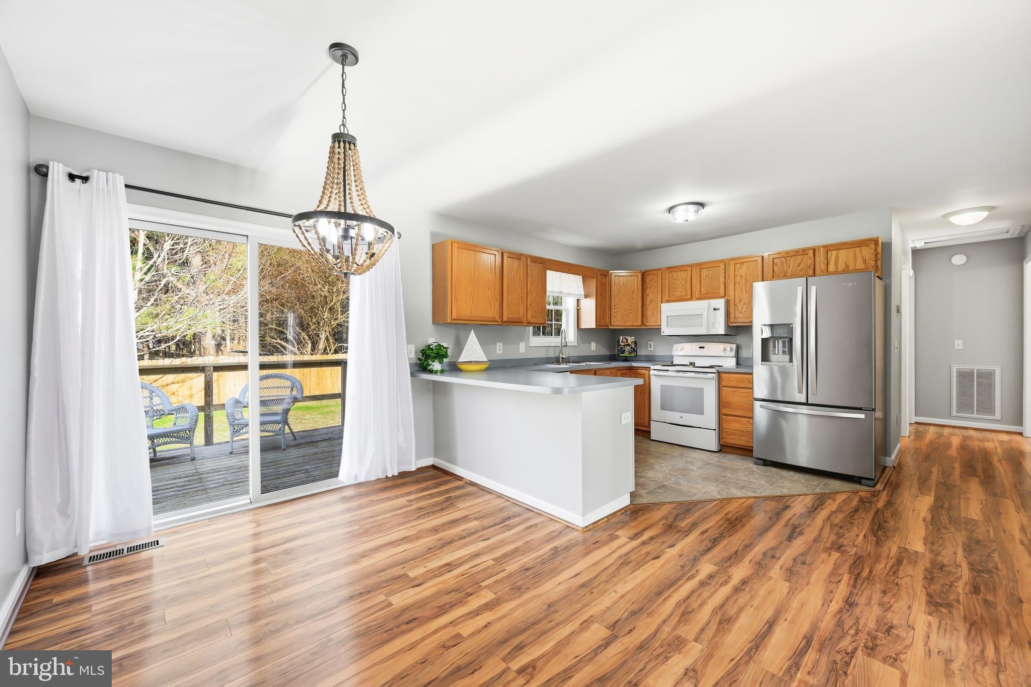 100 Bush Terrace St. Michaels, MD 21663 - Photo 13 of 40 a kitchen with stainless steel appliances granite countertop a refrigerator sink and wooden floor