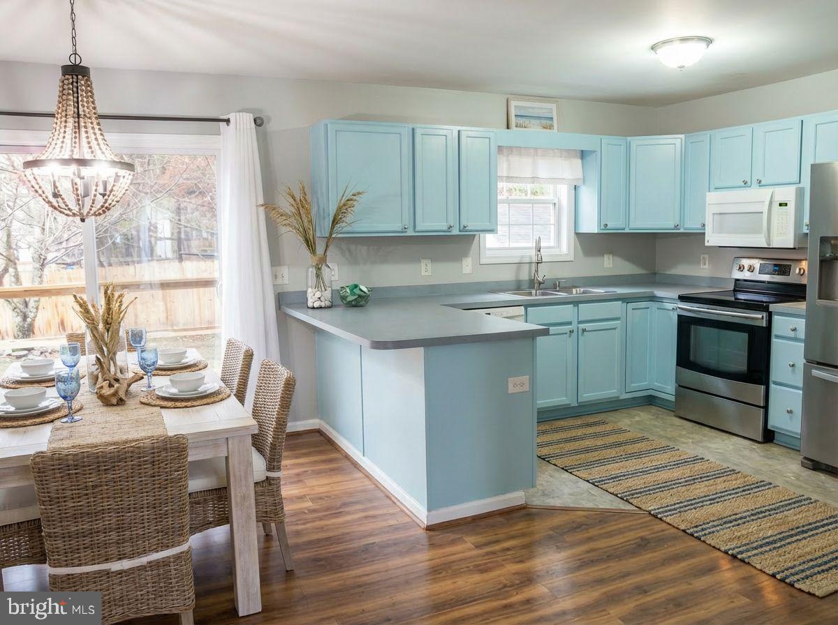 100 Bush Terrace St. Michaels, MD 21663 - Photo 15 of 40 a kitchen with kitchen island granite countertop a sink cabinets and wooden floor