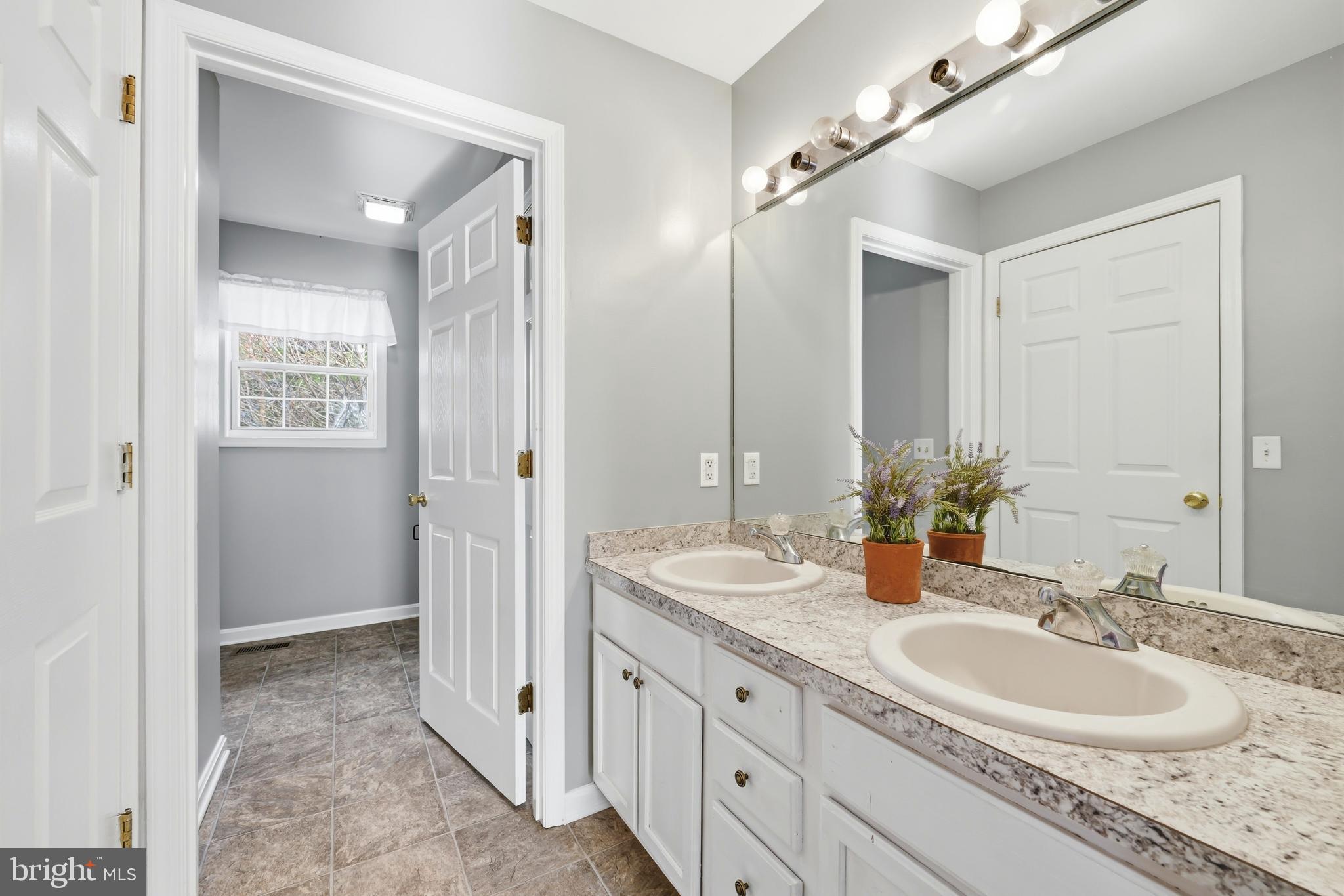 100 Bush Terrace St. Michaels, MD 21663 - Photo 23 of 40 a bathroom with a double vanity sink and a mirror
