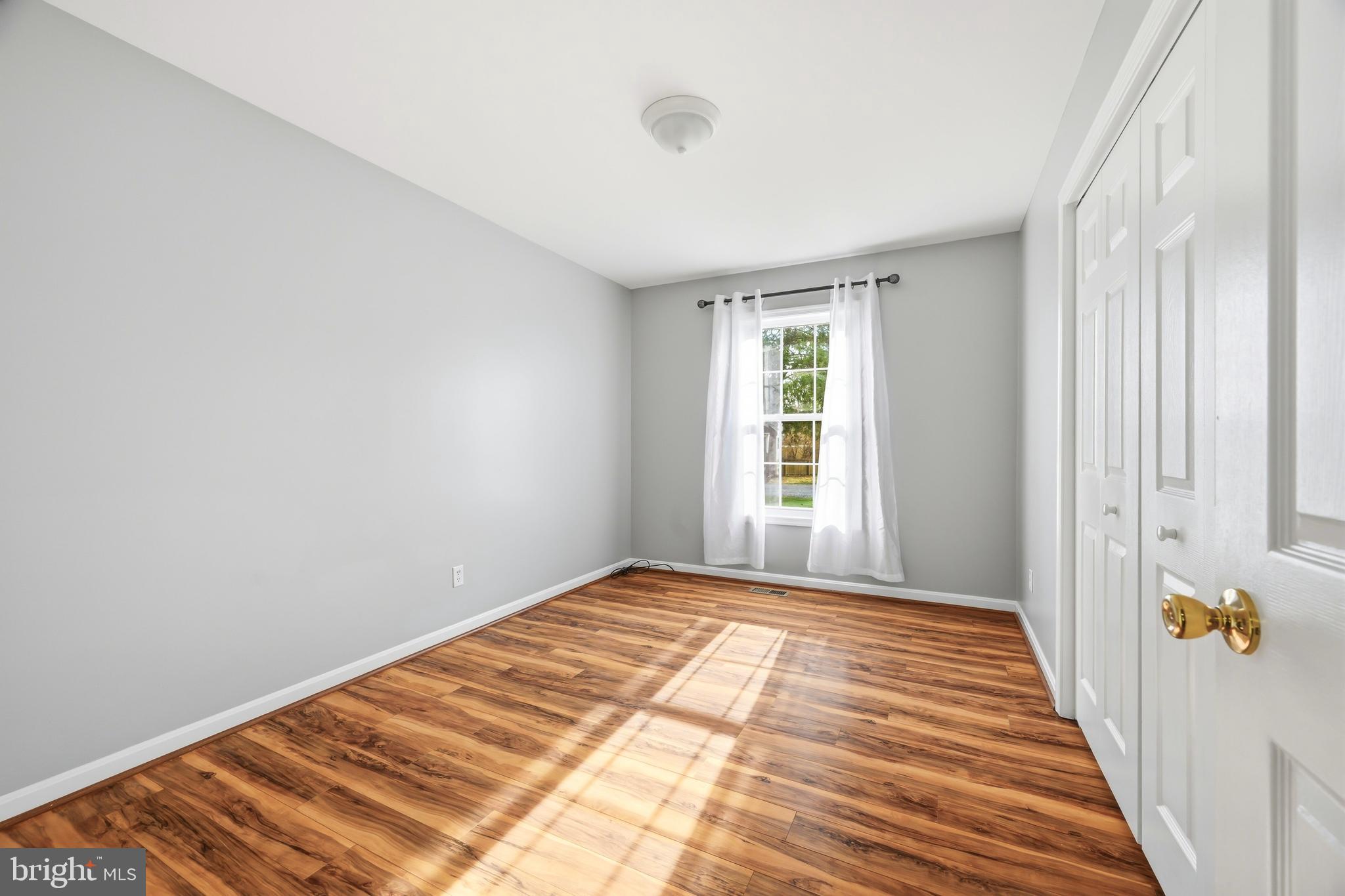 100 Bush Terrace St. Michaels, MD 21663 - Photo 27 of 40 a view of a bedroom with wooden floor and a window