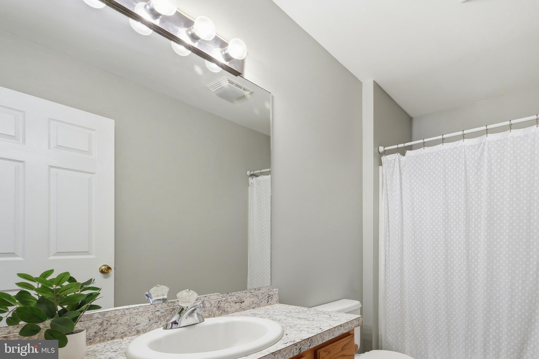 100 Bush Terrace St. Michaels, MD 21663 - Photo 34 of 40 a bathroom with a granite countertop sink and a mirror