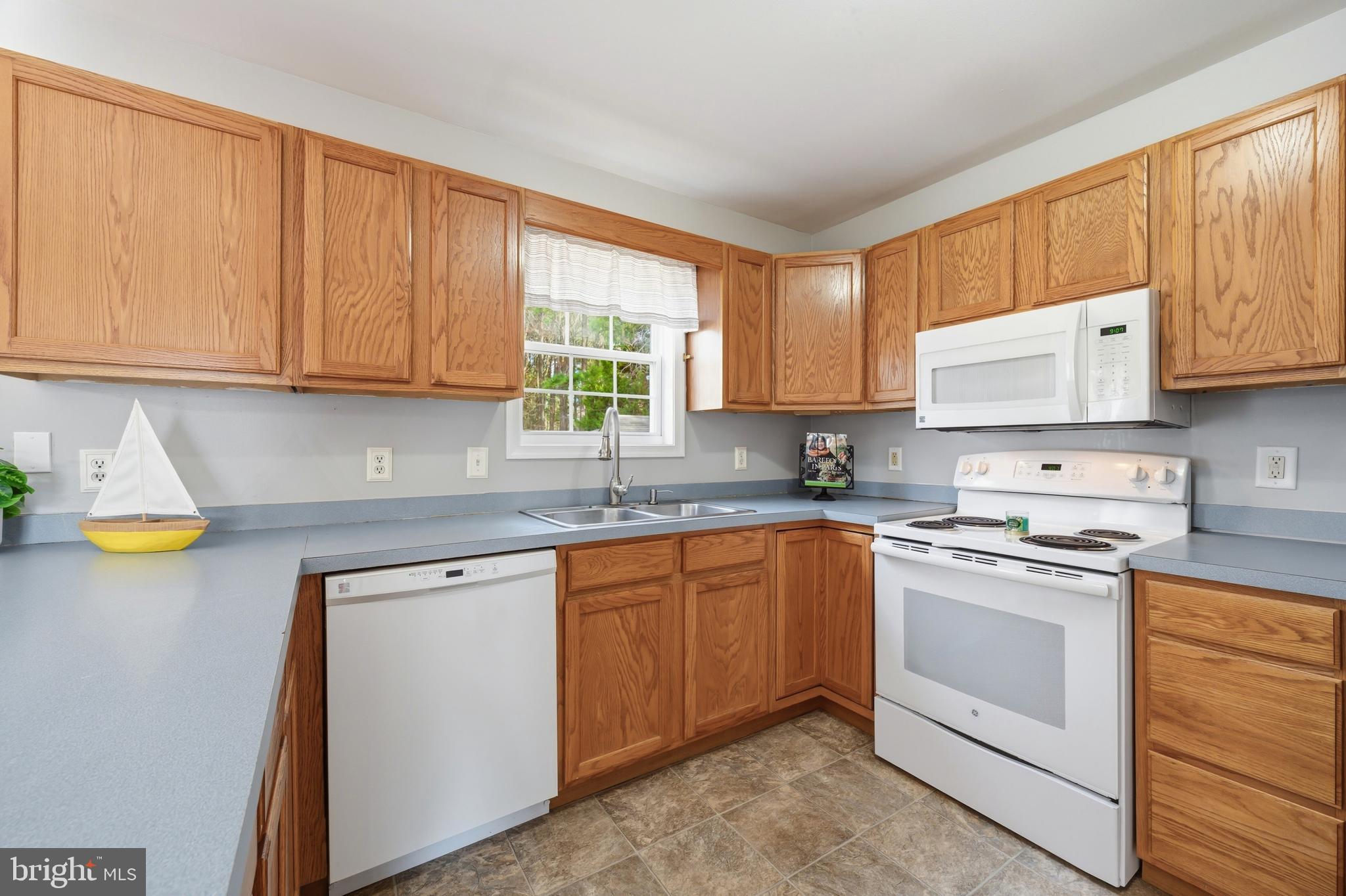 100 Bush Terrace St. Michaels, MD 21663 - Photo 10 of 40 a kitchen with stainless steel appliances granite countertop a stove a sink and a microwave