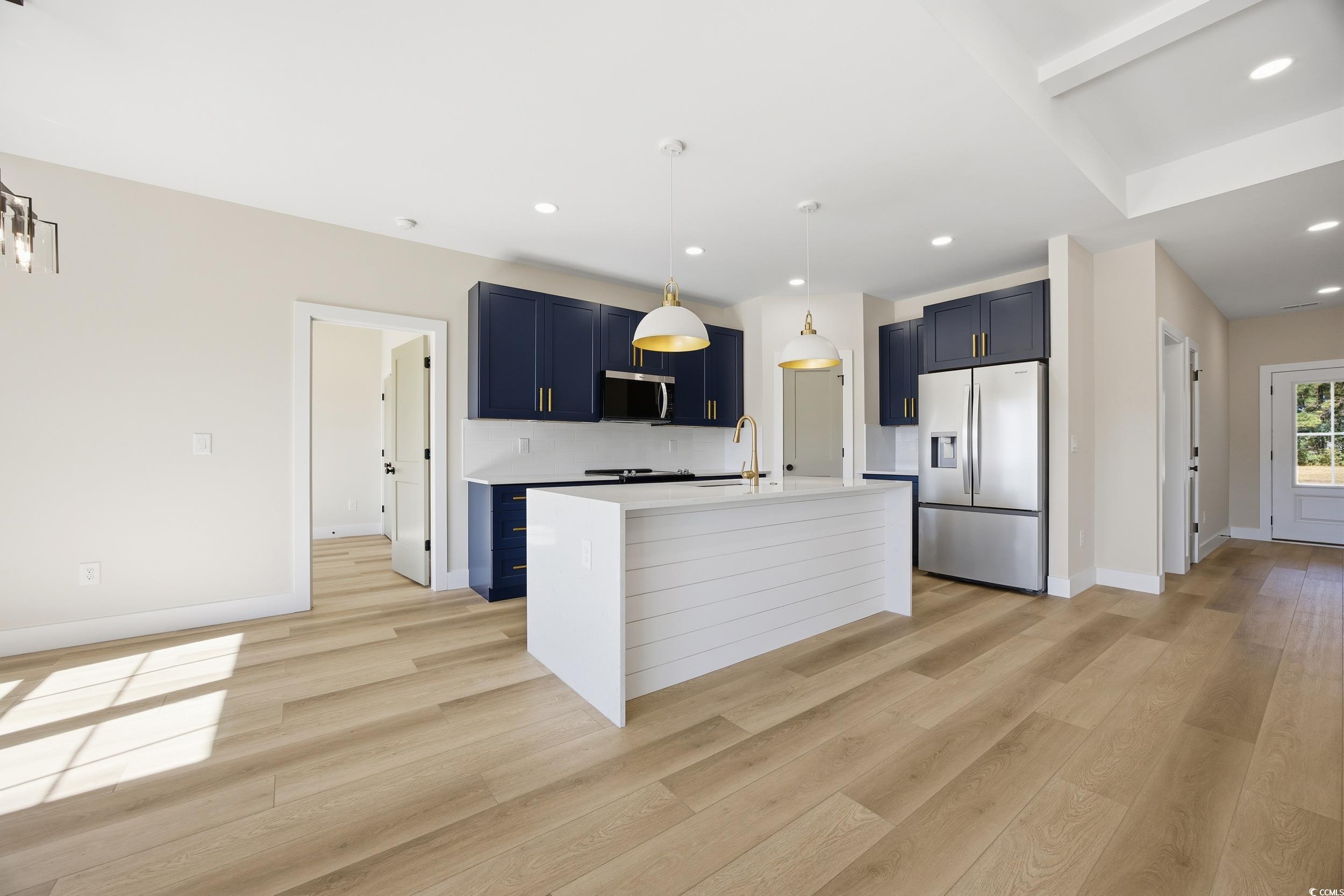 631 Highway 548 Conway Sc 29527 Conway, SC 29527 - Photo 11 of 40 Kitchen featuring stainless steel appliances, hanging light fixtures, an island with sink, blue cabinets, and light wood finished floors