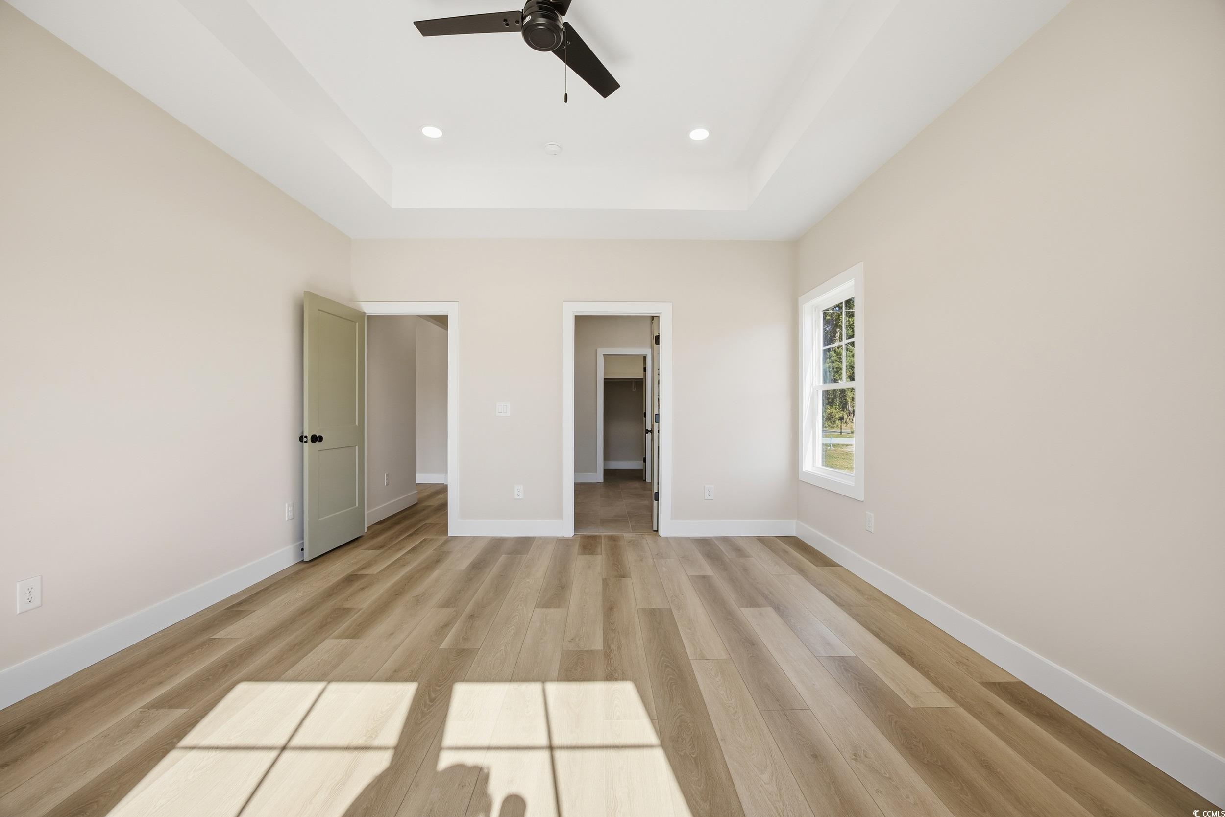 631 Highway 548 Conway Sc 29527 Conway, SC 29527 - Photo 16 of 40 Unfurnished bedroom featuring a spacious closet, light wood-style floors, ceiling fan, a tray ceiling, and recessed lighting