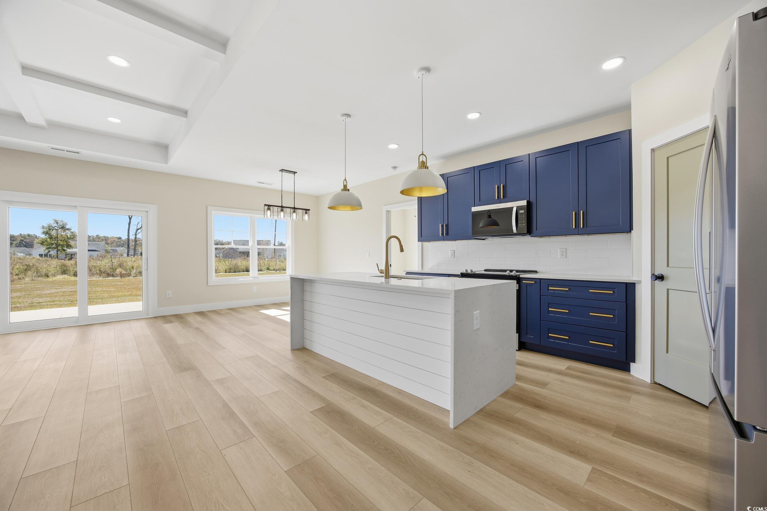 631 Highway 548 Conway Sc 29527 Conway, SC 29527 - Photo 9 of 40 Kitchen with appliances with stainless steel finishes, decorative backsplash, light stone counters, a kitchen island with sink, and pendant lighting