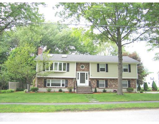 74 Old Farm Road Reading, MA 01867 - Photo 1 of 8 a front view of a house with a garden
