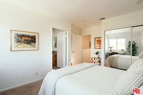 a bedroom with a bed and a painting on the wall