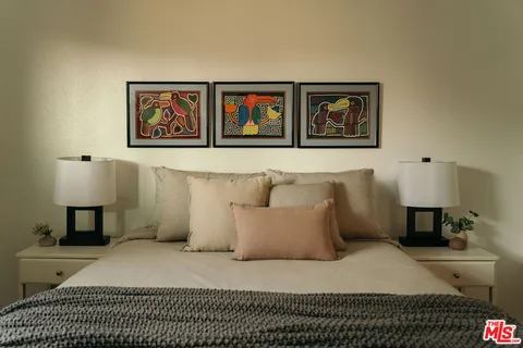 a spacious bedroom with a bed and a lamp on table