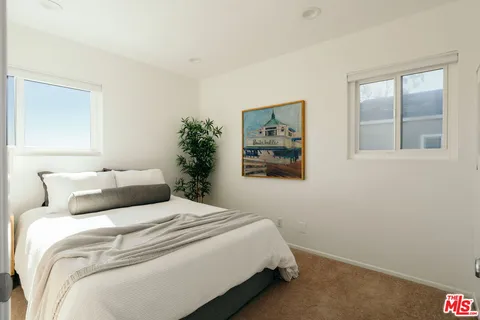 a bedroom with a bed and a painting on the wall