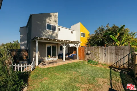 a view of a house with a yard and furniture