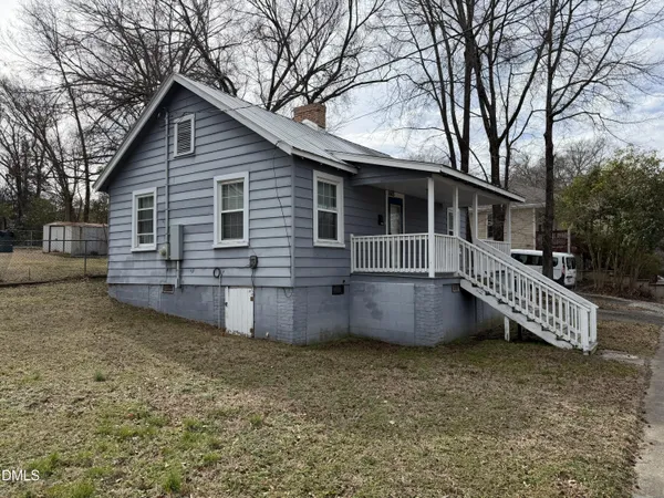 a view of a house with a yard and wooden fence