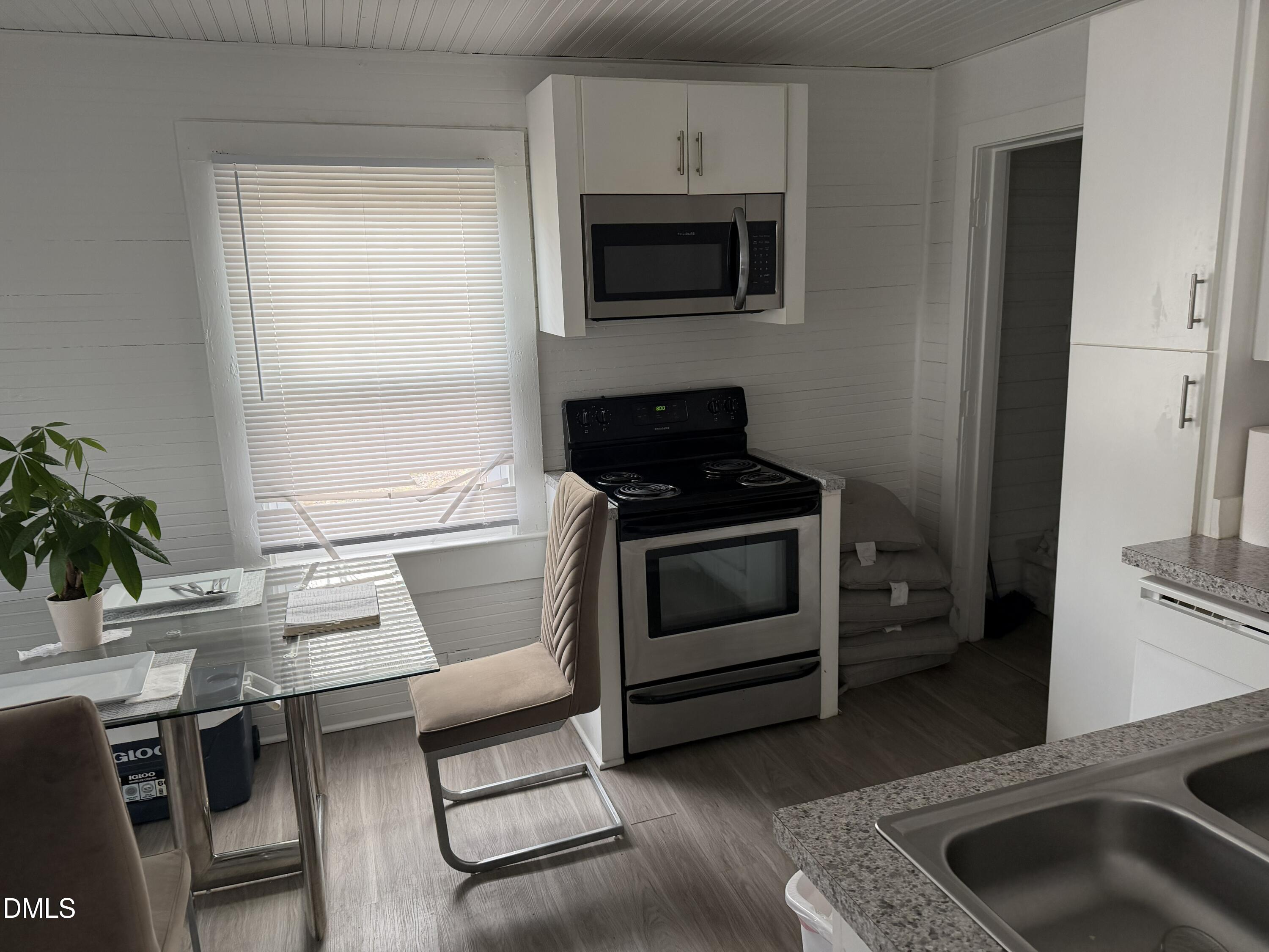 927 Berkeley Street Durham, NC 27705 - Photo 8 of 13 a kitchen with a stove a microwave and a counter top space