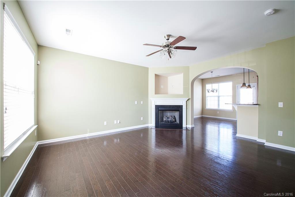 228 Falling Ridge, Unit 151 Belmont, NC 28012 - Photo 2 of 15 a view of empty room with wooden floor and fireplace