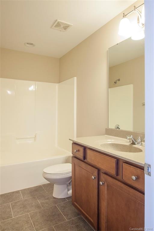 228 Falling Ridge, Unit 151 Belmont, NC 28012 - Photo 11 of 15 a bathroom with a granite countertop sink a toilet and a mirror