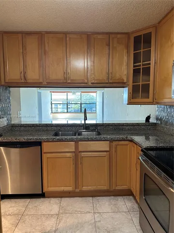 a kitchen with granite countertop cabinets and stainless steel appliances