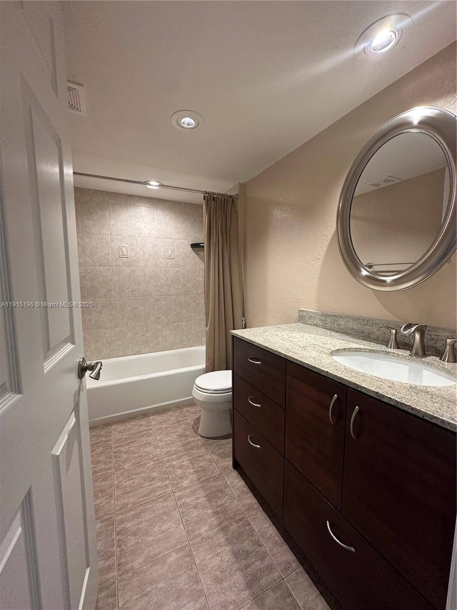 1526 Whitehall Drive, Unit 403 Davie, FL 33324 - Photo 10 of 16 a bathroom with a double vanity sink toilet mirror and bathtub