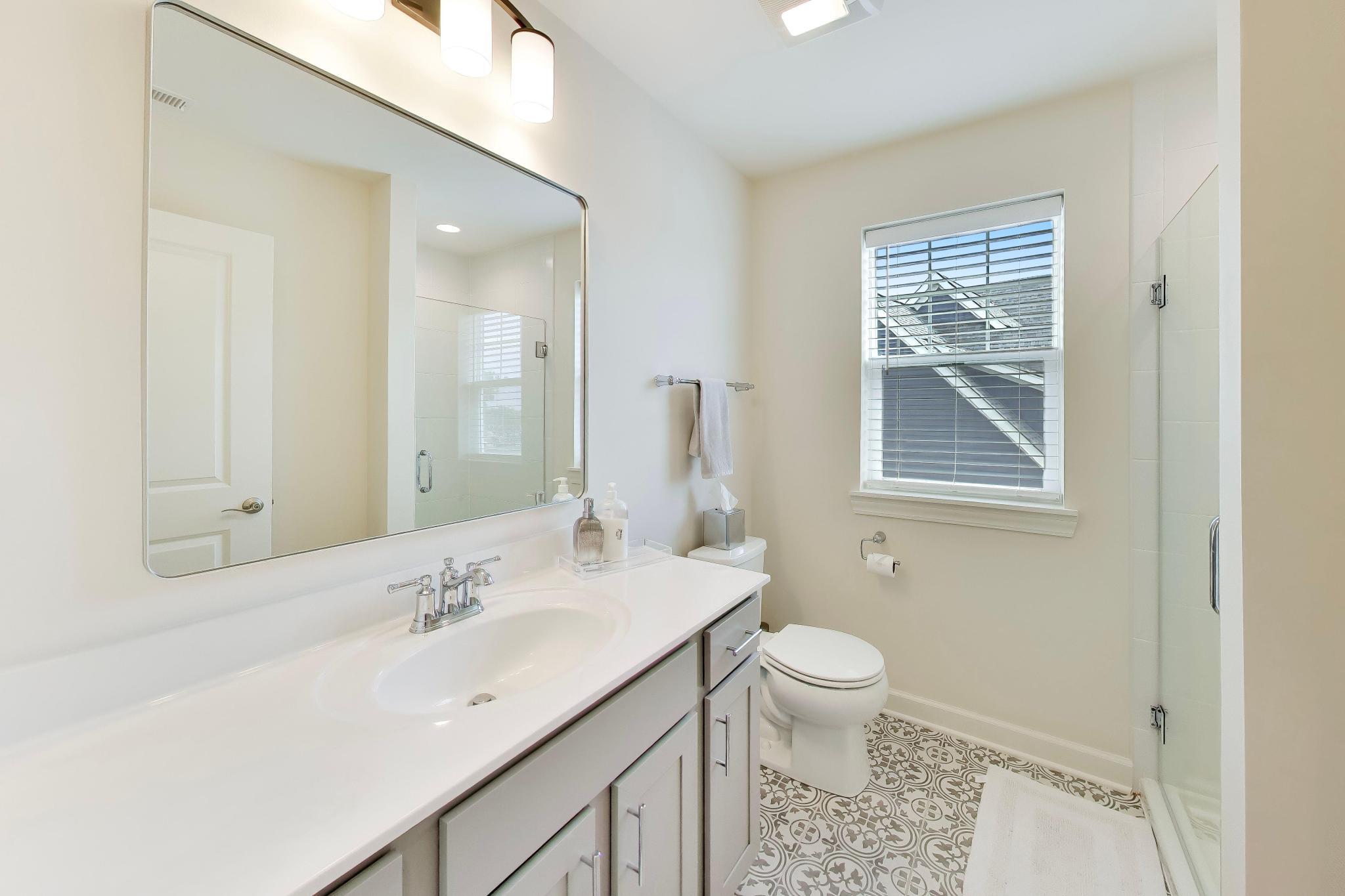 2730 Harbor Court Delavan, WI 53115 - Photo 29 of 47 Upper-level en-suite bathroom with vanity, large mirror, patterned tile floor, and glass shower.