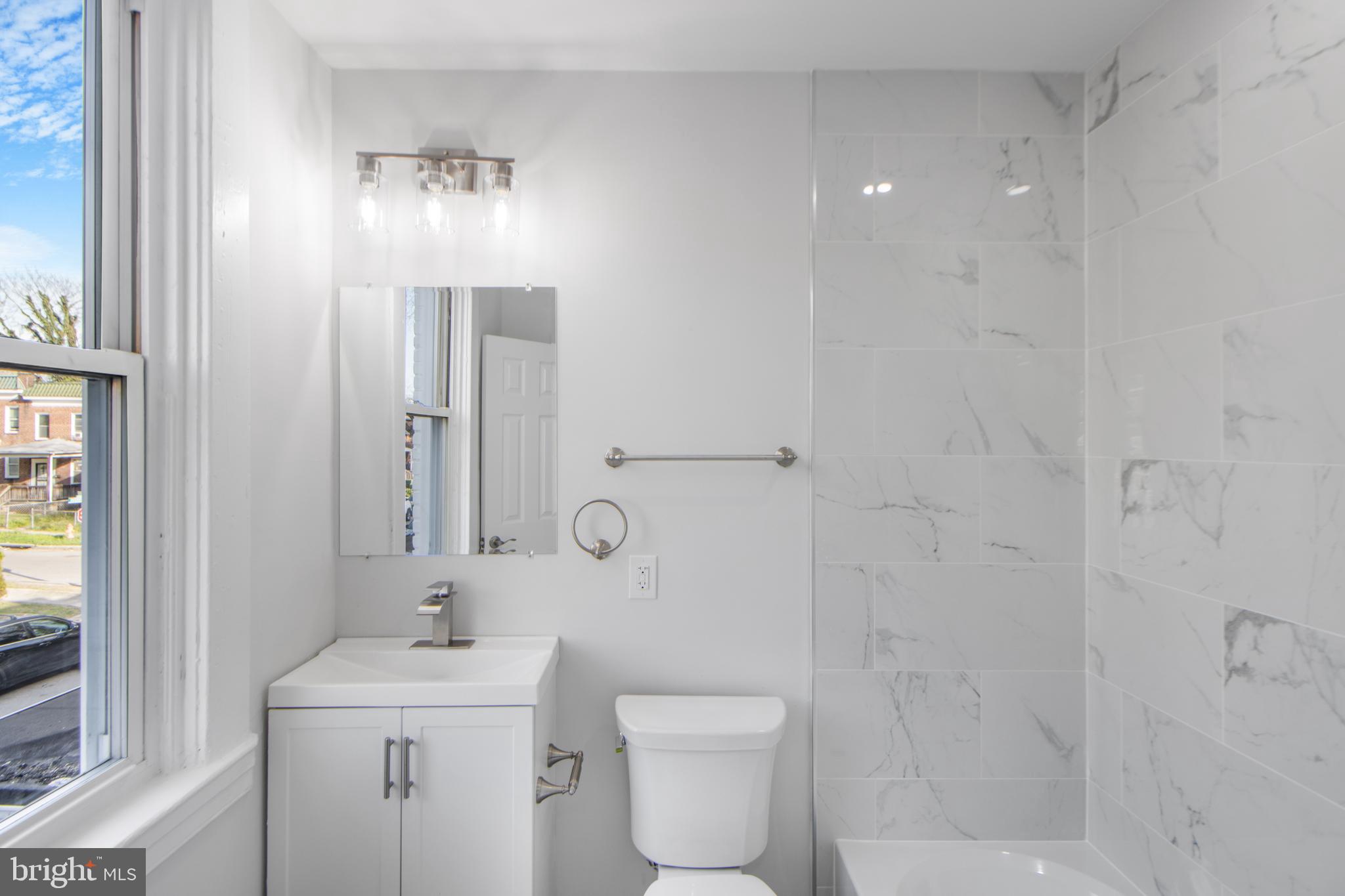 3706 Overview Road Baltimore, MD 21215 - Photo 18 of 47 a bathroom with a toilet a sink and mirror