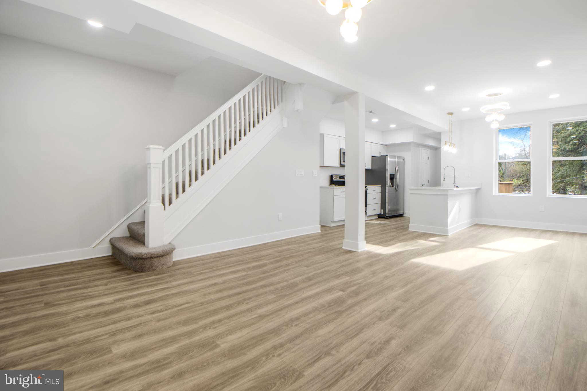3706 Overview Road Baltimore, MD 21215 - Photo 6 of 47 a view of an empty room and a kitchen with wooden floor