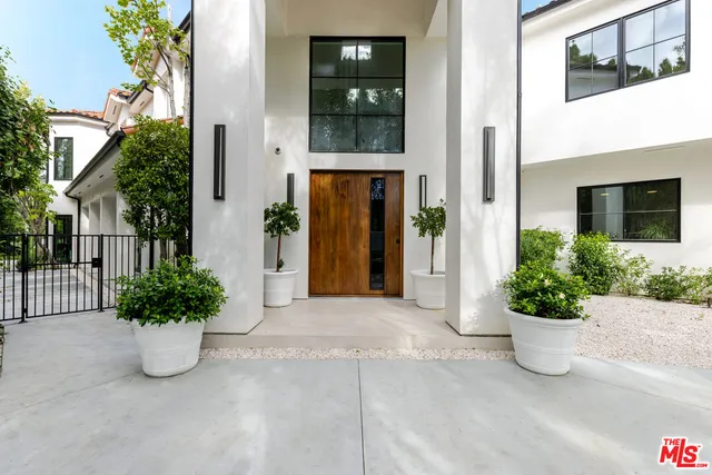 a view of a entryway door with flower pots