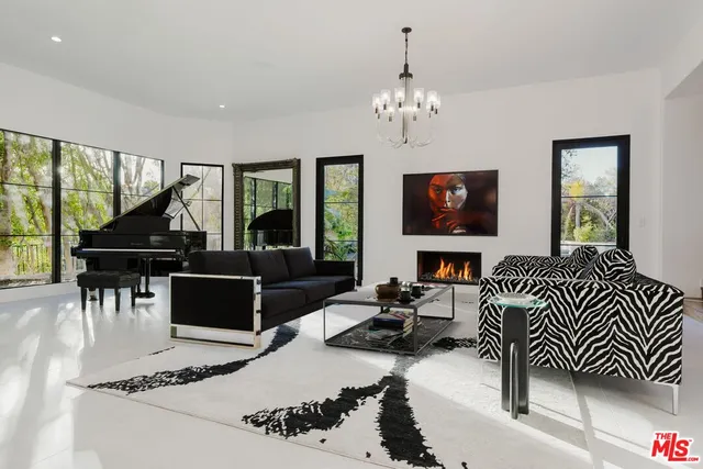 a living room with furniture a fireplace and a chandelier