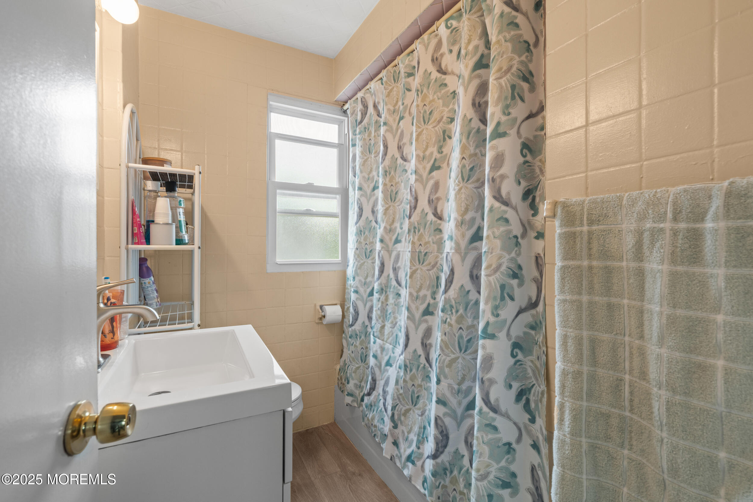 175 Shore Avenue Bogota, NJ 07603 - Photo 19 of 37 a bathroom with a sink a toilet and shower curtain