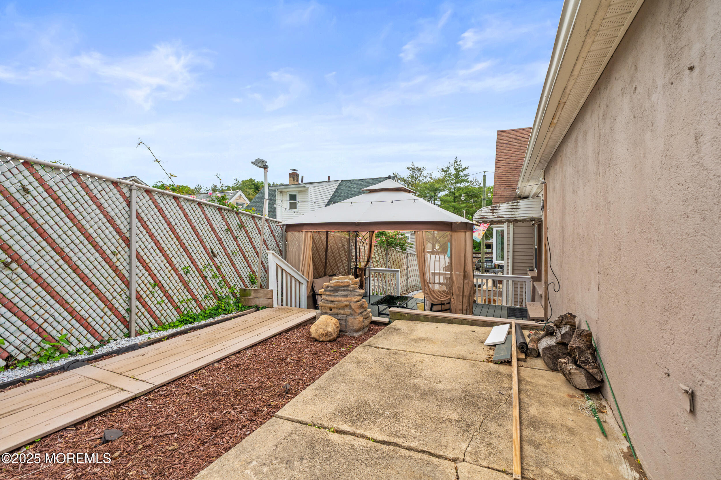 175 Shore Avenue Bogota, NJ 07603 - Photo 32 of 37 a view of a patio with a table and chairs under an umbrella with wooden fence