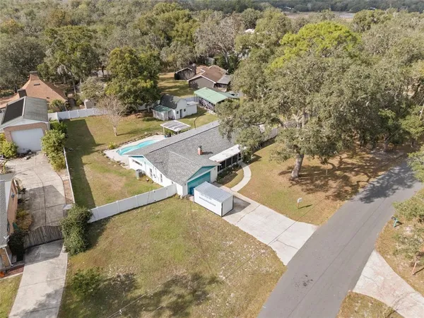 an aerial view of a house with a yard and lake view