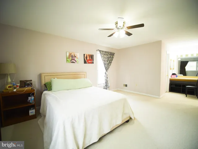 a spacious bedroom with a bed and a chandelier