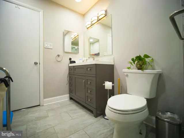 a bathroom with a toilet mirror vanity and a sink