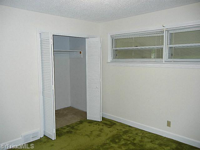 1094 Hickory Tree Road Winston-Salem, NC 27127 - Photo 10 of 16 2nd Bedroom. Second bedroom has a spacious closet and hardwood flooring under the carpet.