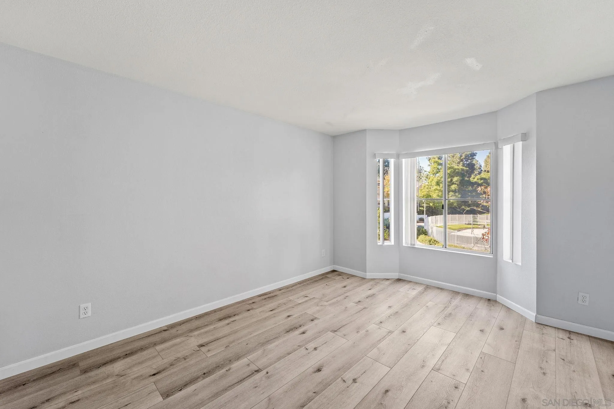 767 Brookstone Road, Unit 201 Chula Vista, CA 91913 - Photo 19 of 56 a view of an empty room with wooden floor and a window