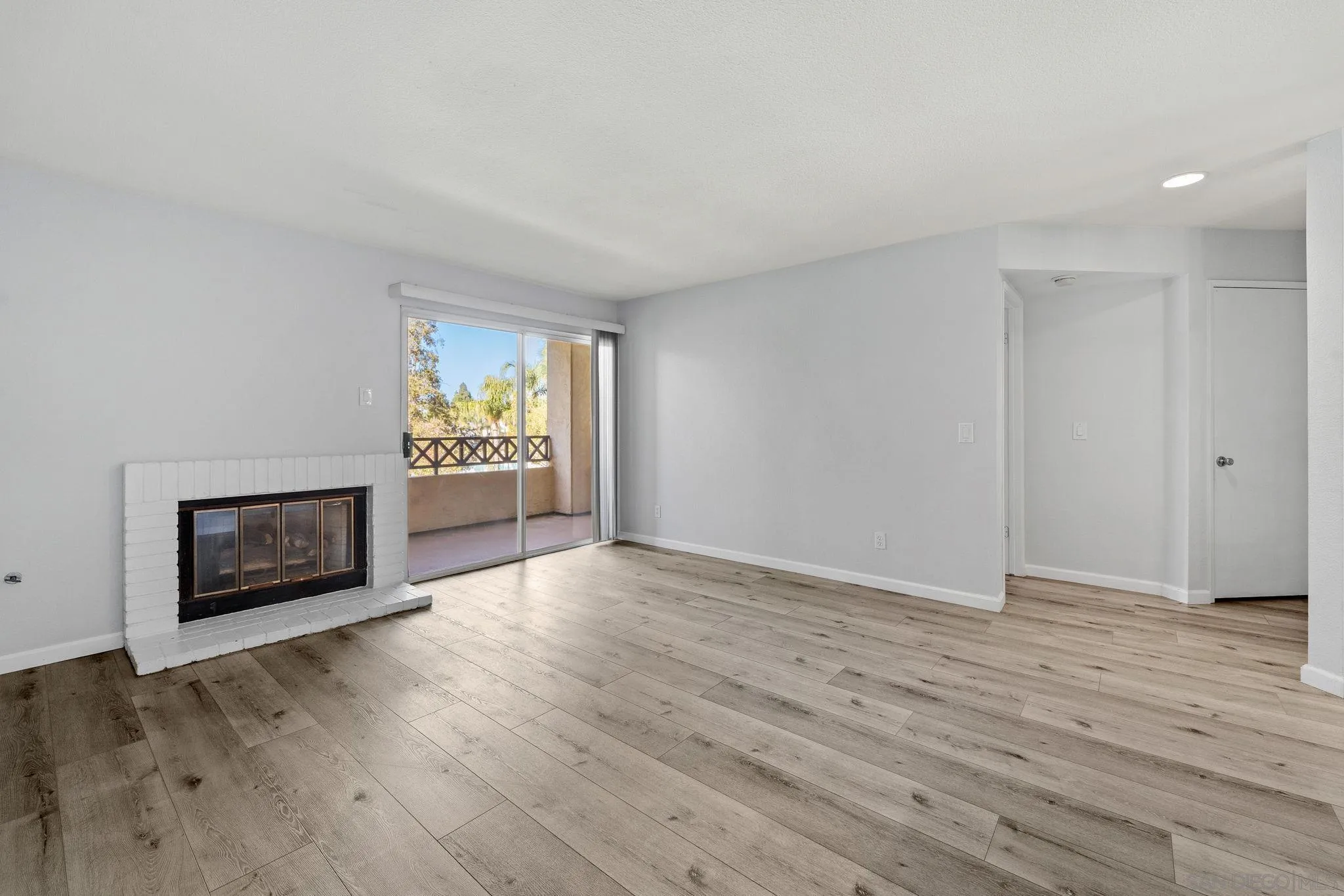 767 Brookstone Road, Unit 201 Chula Vista, CA 91913 - Photo 7 of 56 an empty room with wooden floor a fireplace and a window