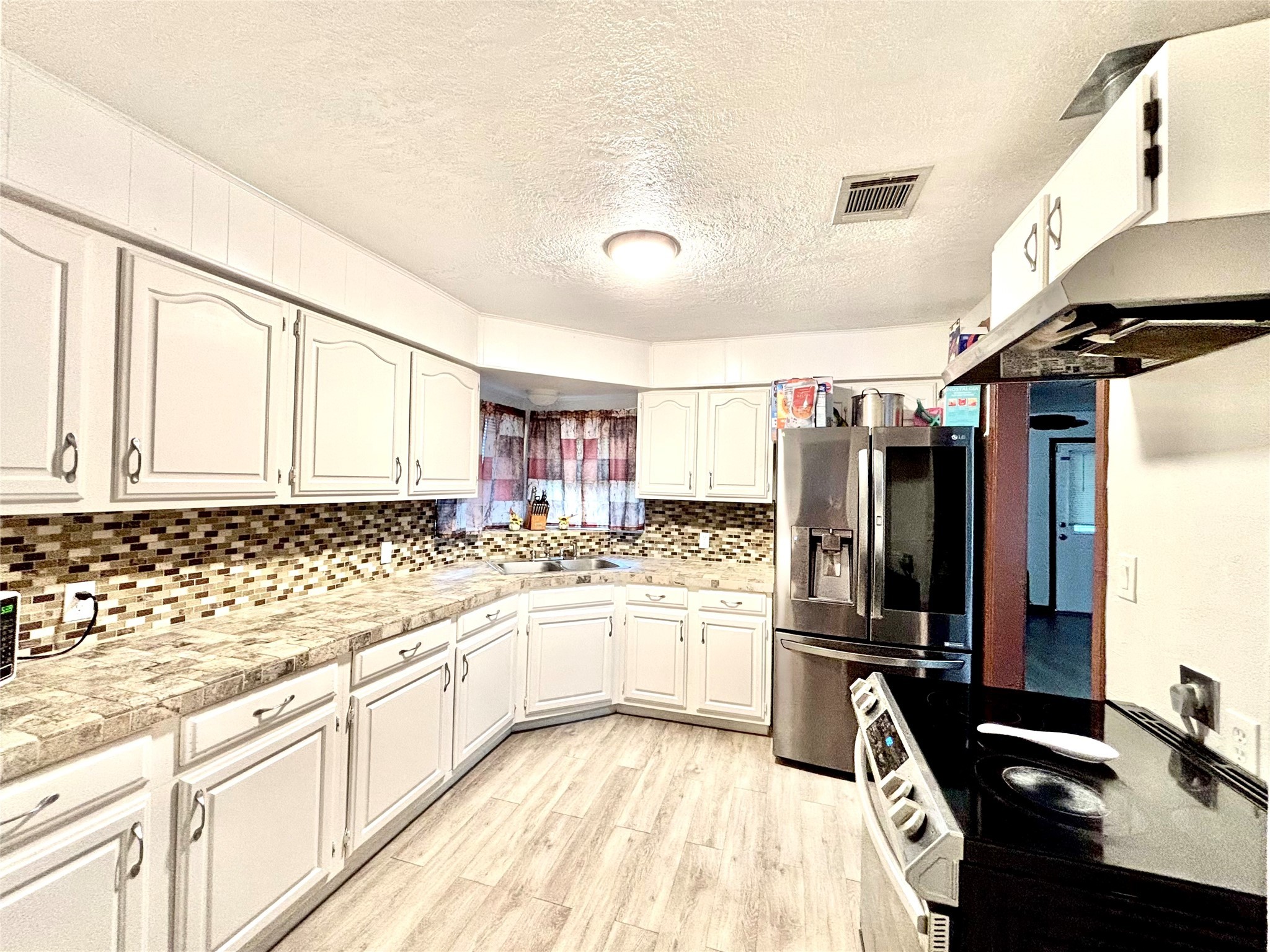 8038 Woodlyn Road Houston, TX 77028 - Photo 6 of 10 a kitchen with stainless steel appliances kitchen island granite countertop a sink stove and cabinets