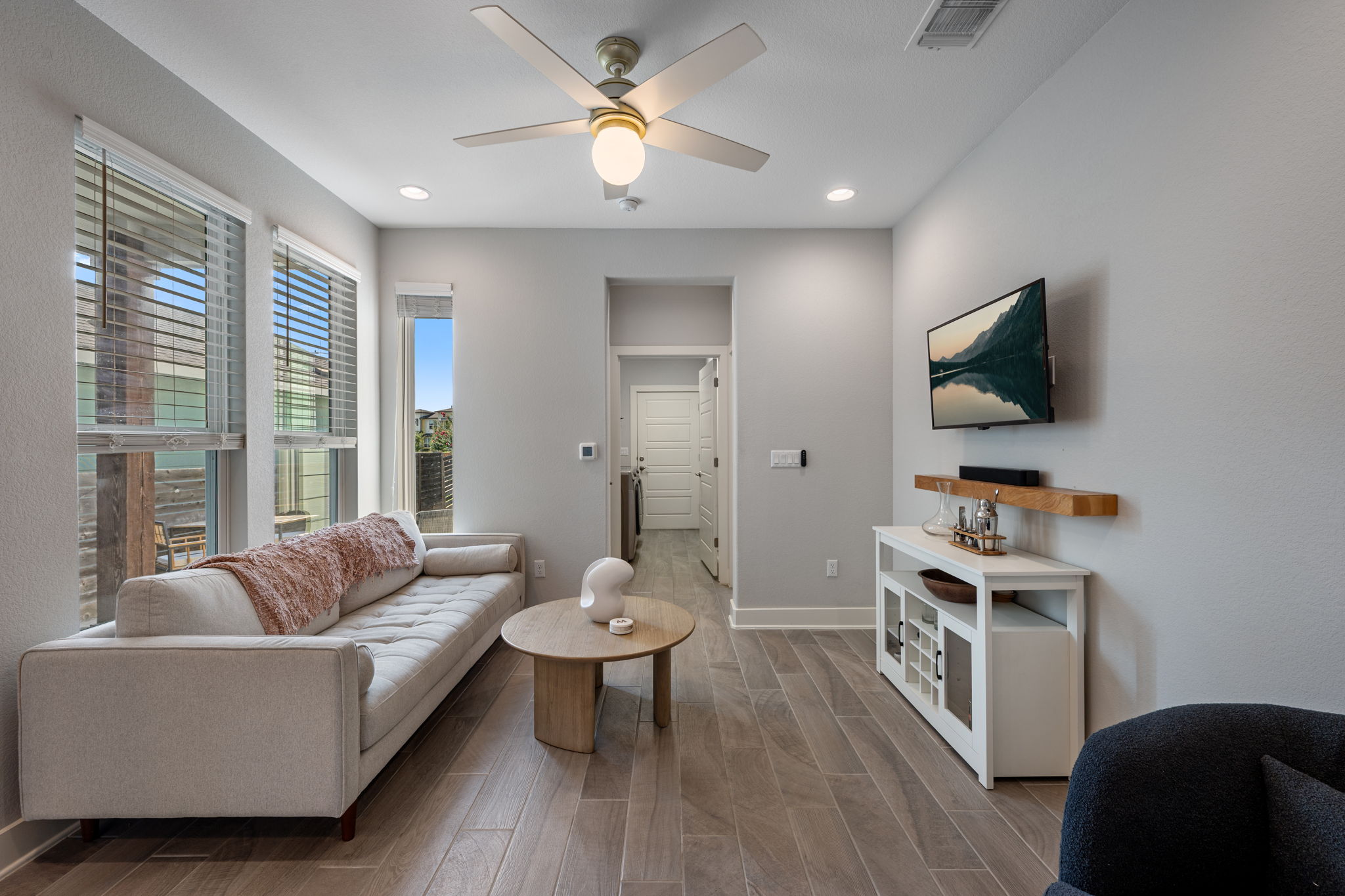 5409 Fox Wing Way Austin, TX 78747 - Photo 7 of 26 Natural light floods this living area, showcasing its streamlined tile flooring and neutral color palette.