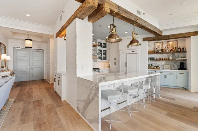 a open kitchen with white cabinets and wooden floor
