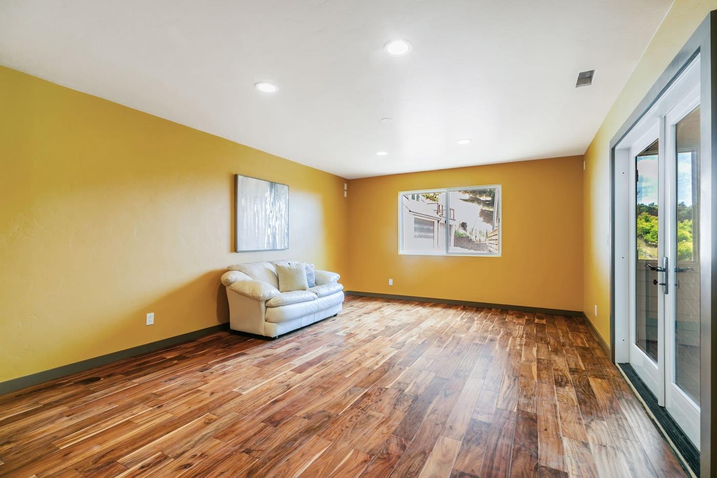 411 Hecker Pass Road Watsonville, CA 95076 - Photo 22 of 76 a living room with hard wood floors and a bed