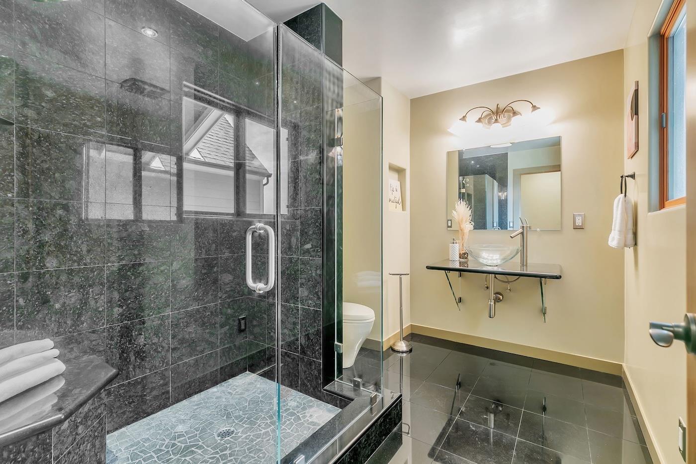 411 Hecker Pass Road Watsonville, CA 95076 - Photo 48 of 76 a bathroom with a granite countertop sink a toilet and shower