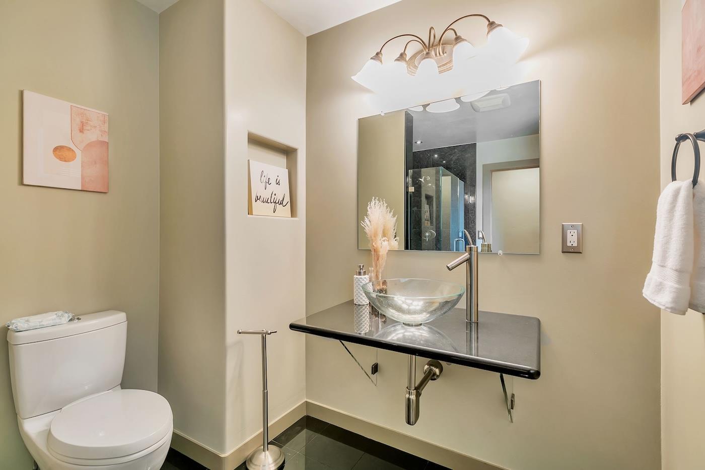 411 Hecker Pass Road Watsonville, CA 95076 - Photo 49 of 76 a bathroom with a granite countertop sink a toilet and mirror