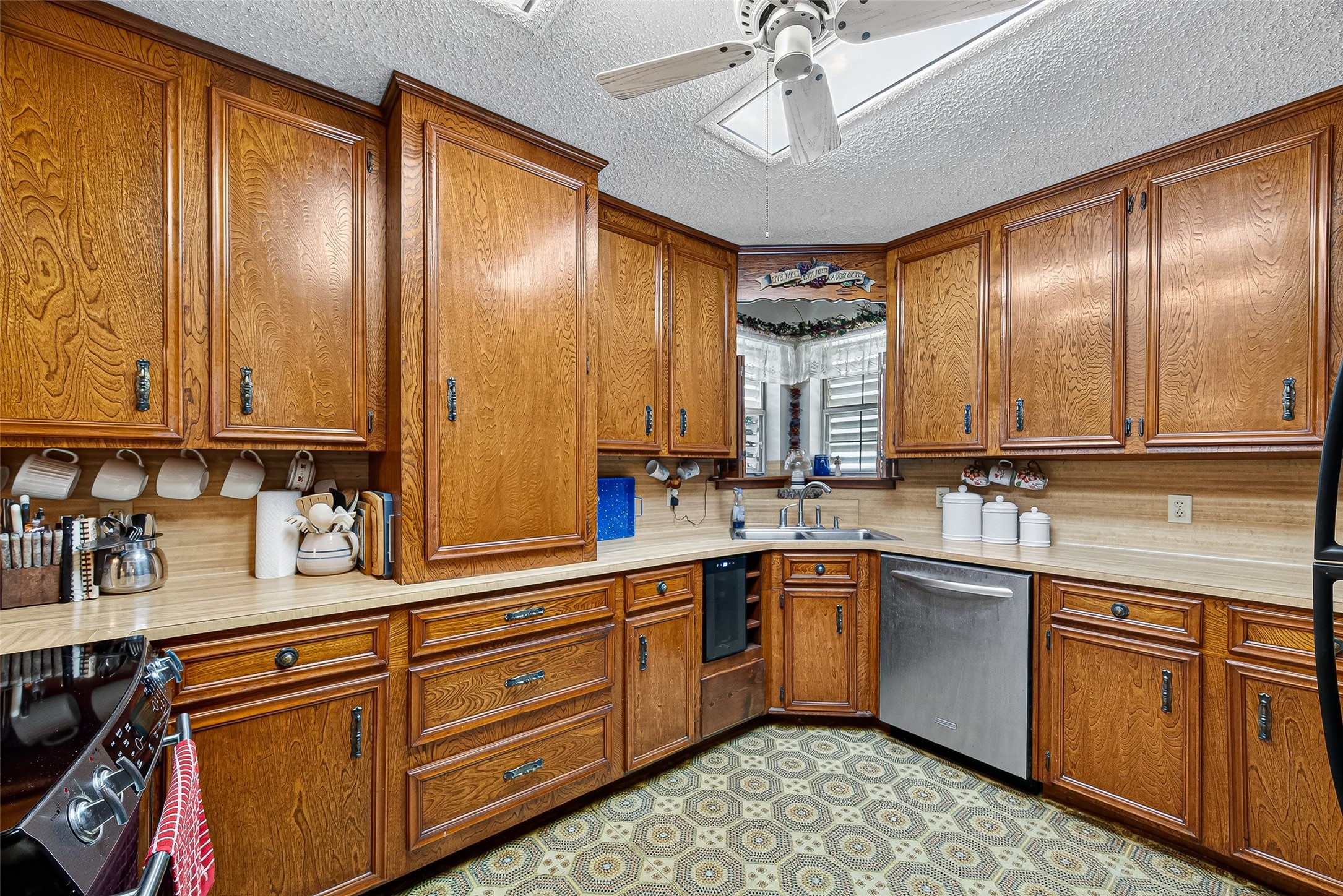12021 7th 1/2 Street Santa Fe, TX 77510 - Photo 25 of 49 This kitchen features classic wooden cabinetry with ample storage, a stainless steel dishwasher, and a cozy corner sink. It has custom made cabinets and a rare large pantry cabinet in the interior of the kitchen making cooking an easy effort.