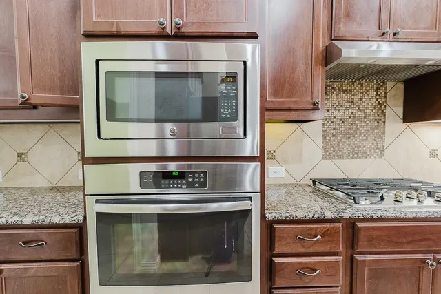 a kitchen with granite countertop a stove and a microwave