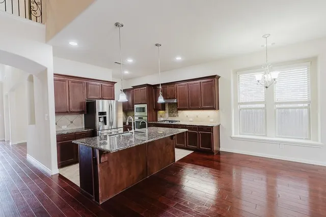 a large kitchen with stainless steel appliances lots of counter top space