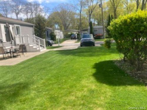 1661 Old Country Road, Unit 49 Riverhead, NY 11901 - Photo 3 of 11 a view of a house with backyard and sitting area