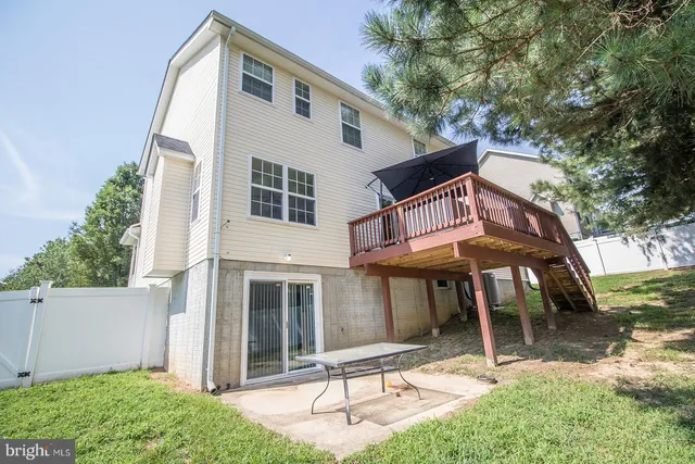 a view of backyard with wooden fence and a large tree
