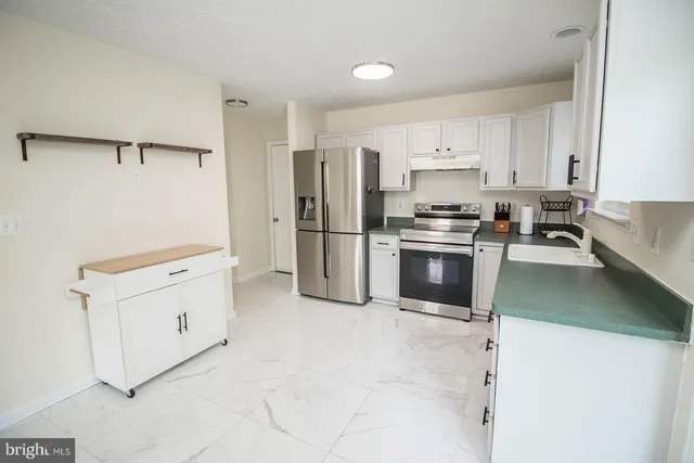 a kitchen with granite countertop white cabinets white appliances and sink
