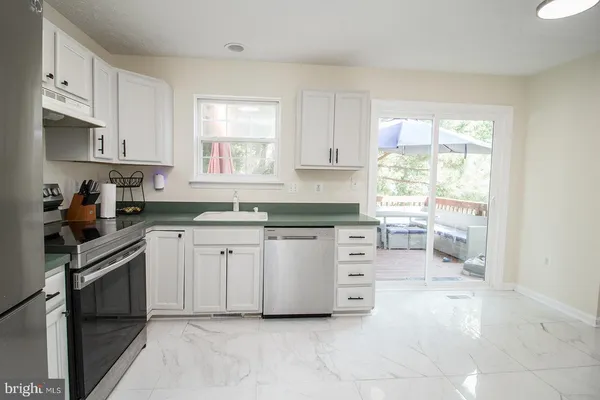 a kitchen with white cabinets and white appliances